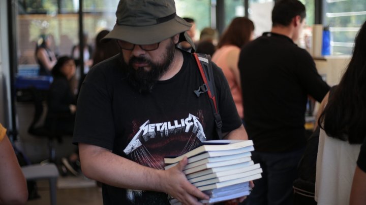 Imagen de hombre llevando muchos libros