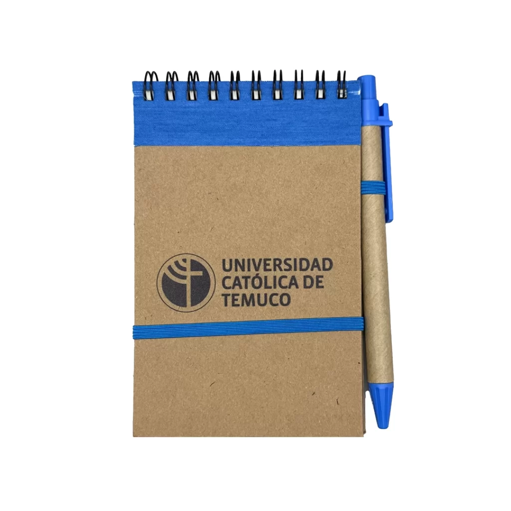 libreta color café claro de papel recicladocon detalles en azul. logo uct impreso en la portada y lápiz adjunto con elástico
